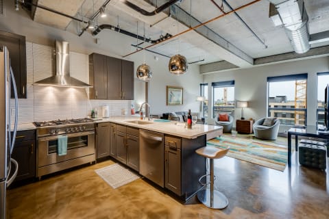 A stylish open-concept apartment featuring a contemporary kitchen and cozy living space.