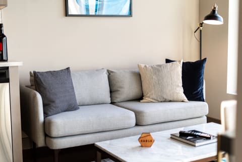 Cozy living room featuring a gray sofa with decorative pillows and a marble coffee table.