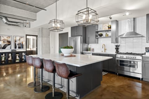 Stylish kitchen with marble countertop island and stainless steel appliances.