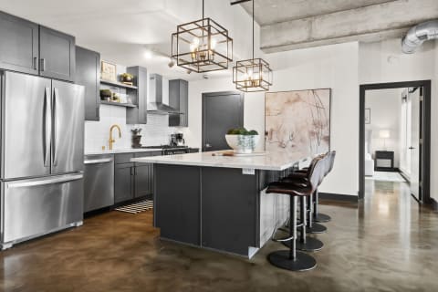 Contemporary kitchen with dark cabinets and marble island.