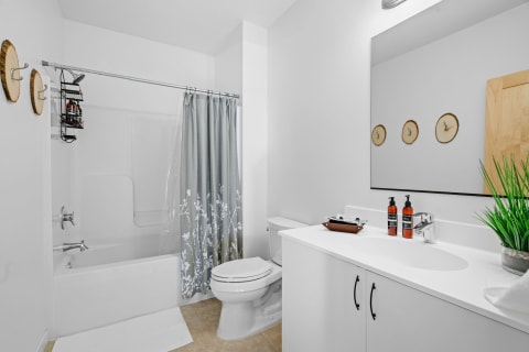 A bright bathroom with a shower, vanity, and decorative wooden hooks.