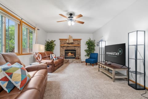 Cozy living room with brown leather recliners, a fireplace, and a television.