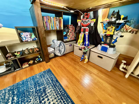 A colorful children's room with toys, books, and a vibrant mural.