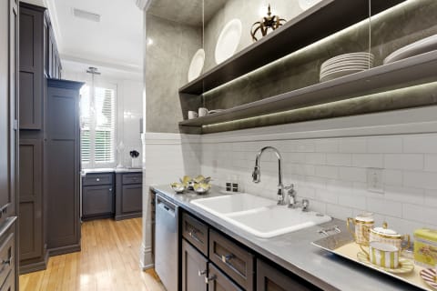Stylish galley kitchen with navy cabinetry, white subway tiles, and open shelving.