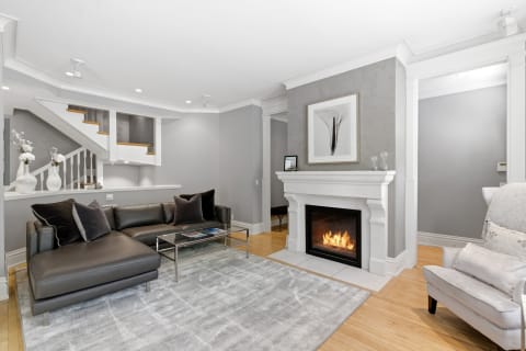 A modern living room with a cozy fireplace, gray sectional sofa, and stylish decor inviting relaxation.