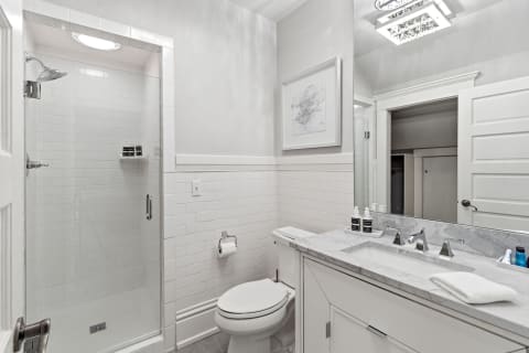 Contemporary bathroom featuring a walk-in shower, marble countertops, and stylish decor.