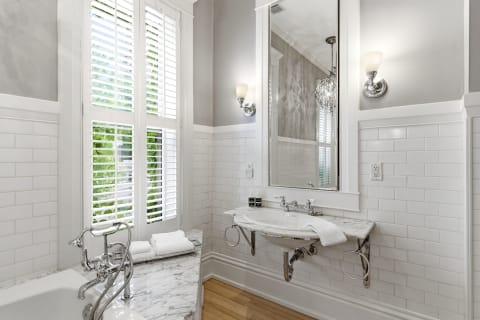 Elegant spa-like bathroom with a soaking tub, marble details, and natural light.