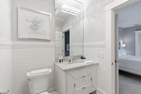 Elegant bathroom with white shiplap accents and a marble countertop, showcasing modern design elements.