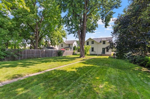 Peaceful residential property nestled among mature trees in a quiet neighborhood setting with manicured green spaces.
