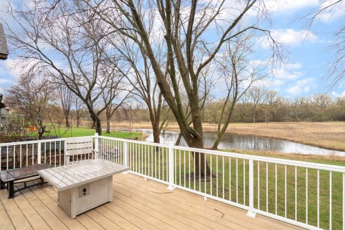 Step onto your private deck and soak in peaceful pond views. The wooden bench invites morning coffee moments while you watch nature unfold.