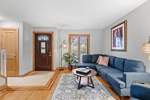 Relax in your stylish living room featuring a plush sectional sofa, warm wood floors, and natural light streaming through large windows.