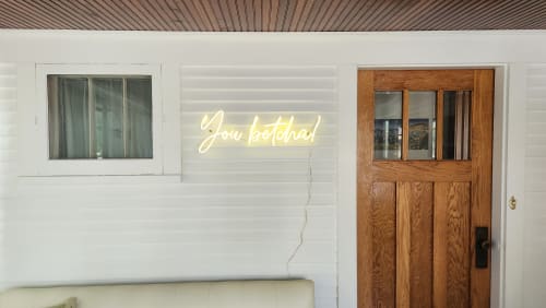 Step through your charming wooden door beneath the glowing 'You bet there!' neon sign—your warm welcome awaits.