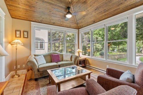 Relax in your sun-drenched living room with soaring wood ceilings and panoramic windows overlooking lush gardens.