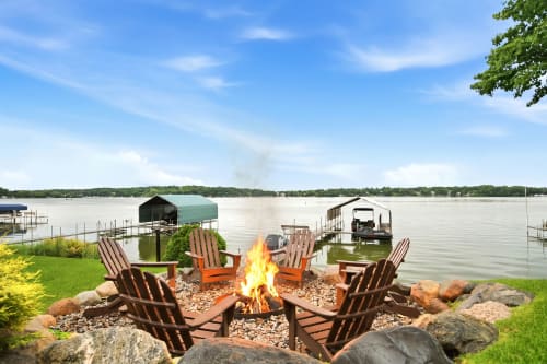 Gather around the fire pit as the sun sets over the lake, surrounded by Adirondack chairs and peaceful waterfront views—perfect for cozy evenings with friends.