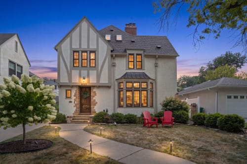 This charming Tudor-style home welcomes you with warm lighting and a beautiful exterior. The property sits in a peaceful, tree-lined neighborhood, perfect for a relaxing getaway.