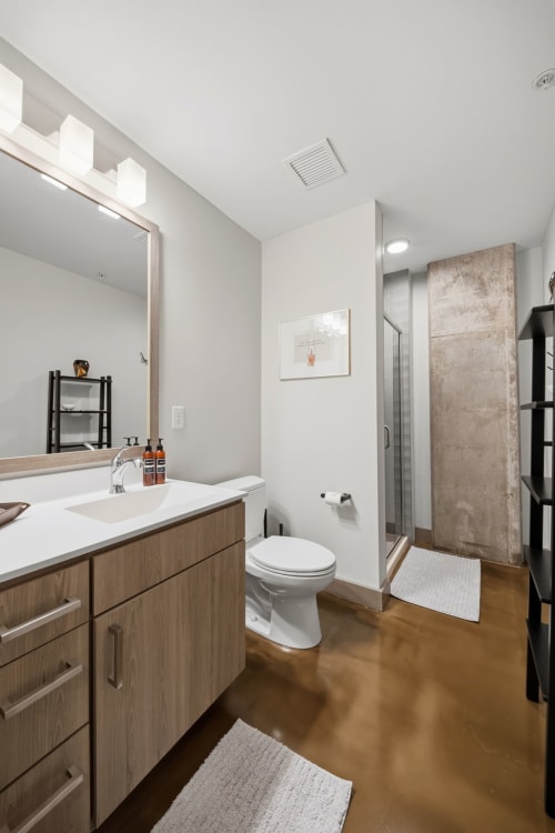 Unwind in your modern bathroom with polished concrete finishes, bright natural light, and a walk-in shower that makes your morning routine feel like a spa retreat.