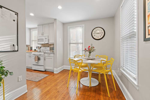 Your bright dining area welcomes you with cheerful yellow chairs and warm hardwood floors, perfect for morning coffee or intimate meals.