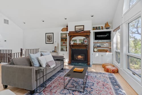 Unwind in your bright living room with cozy fireplace, plush seating, and stunning windows that frame peaceful views.