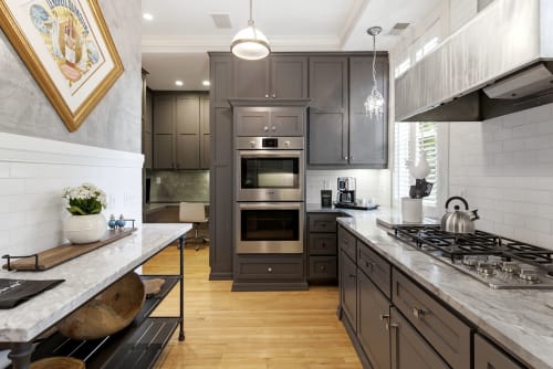 Your gourmet kitchen features sleek gray cabinetry, premium stainless appliances, and gleaming marble countertops—perfect for creating delicious meals during your stay.